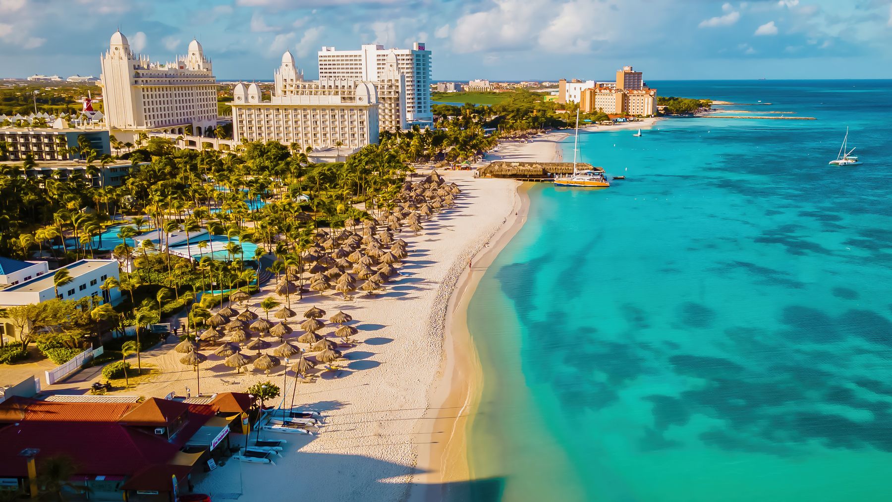 Praia de Aruba vista do alto, com hotéis, coqueiros e mar turquesa