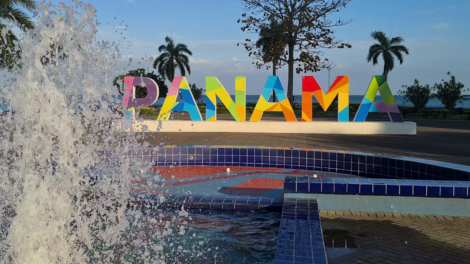 Letreiro colorido com a palavra Panamá na orla da Cidade do Panamá, com fonte em primeiro plano